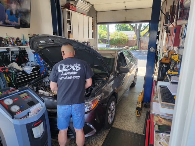 Auto repair shop owner performing engine diagnostics